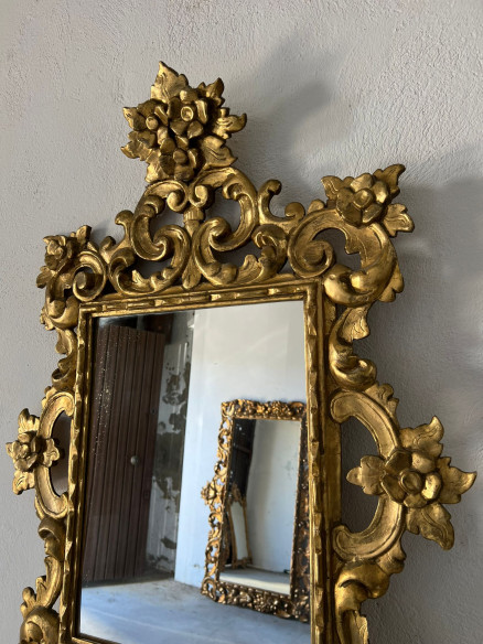 Espejo tallado en madera con adornos florales y dorado