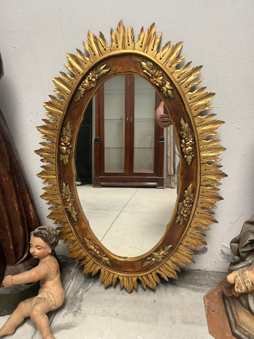 Espejo de Sol en madera con flores talladas.