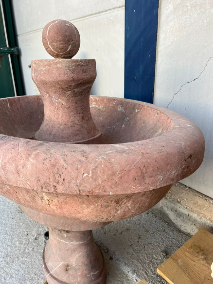 Fuente central de mármol rojo ovalada.