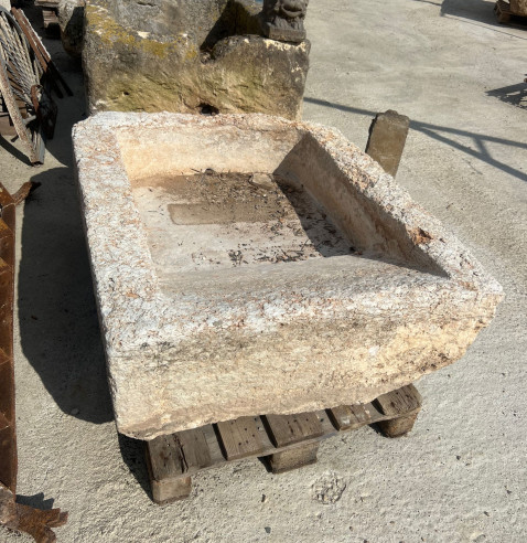 Pilón en piedra blanca con lavadera y medio punto.