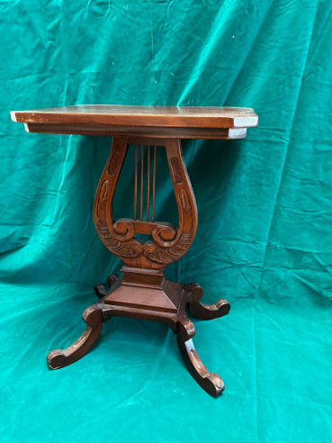 Elegante mesa auxiliar con pie forma de arpa.