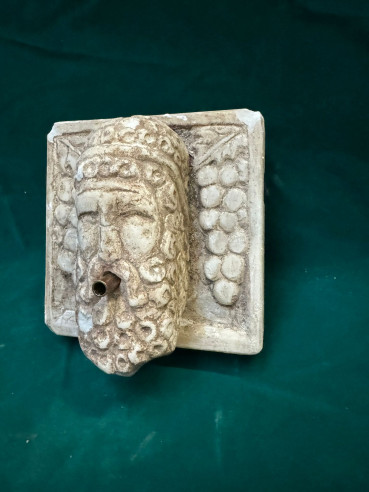 Mascarón de fuente tallado en mármol.