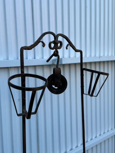 Pequeño brocal de pozo con polea y soporte para dos cántaros.