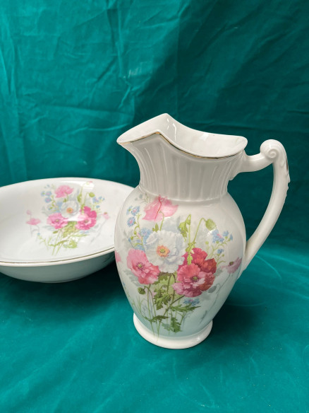 Conjunto de palangana y jarra, con filos dorados y adornos florales.