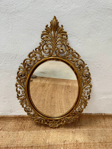 Espejo ovalado con bonito marco finamente tallado y dorado.