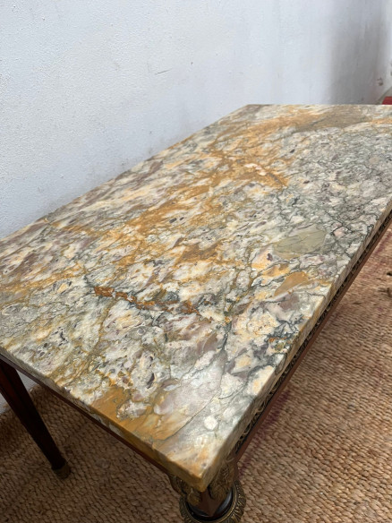 Mesa de centro con tapa de mármol veteada.