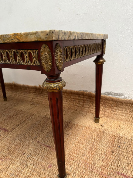 Mesa de centro con tapa de mármol veteada.