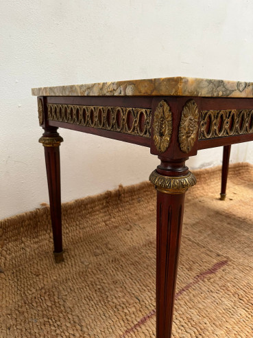 Mesa de centro con tapa de mármol veteada.