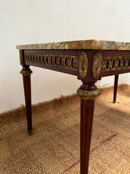 Mesa de centro con tapa de mármol veteada.