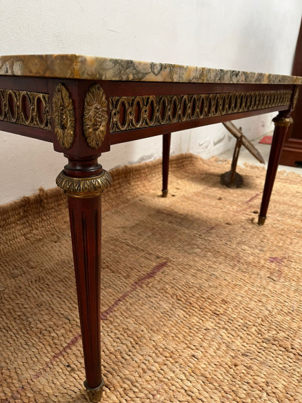 Mesa de centro con tapa de mármol veteada.