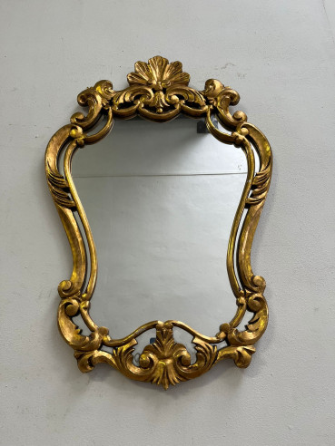 Elegante espejo dorado tallado en madera.