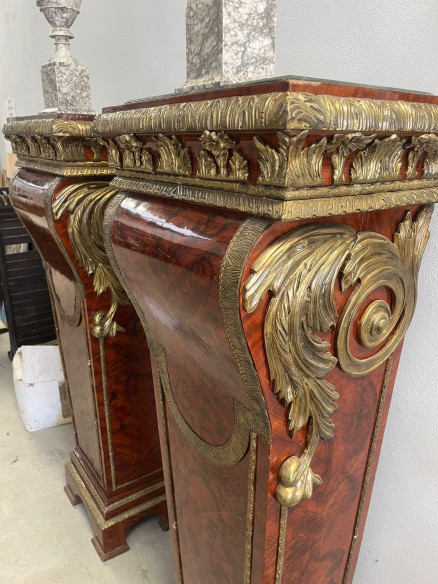 Pedestales con adornos bronces y base de mármol.