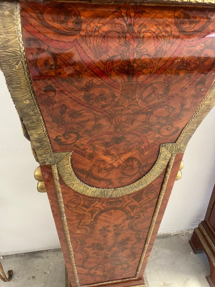 Pedestales con adornos bronces y base de mármol.