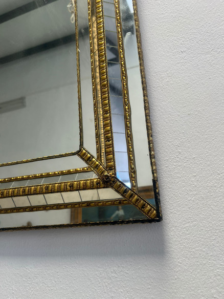 Espejo estilo vintage sobre madera con adornos en latón  y elaborado trabajo.