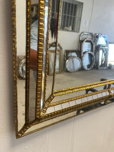 Espejo estilo vintage sobre madera con adornos en latón  y elaborado trabajo.