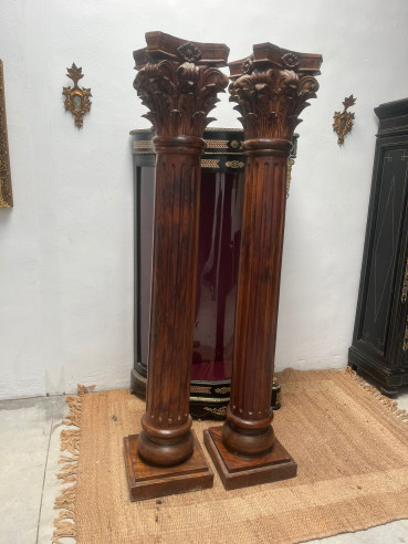 Pareja de columnas talladas en madera con capiteles corintios.