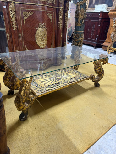 Mesa baja de centro con patas de dragones alados en hierro fundido y tapa de cristal.