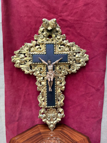 Cruz dorada tallada en madera con cristo de olot con ojos de cristal.