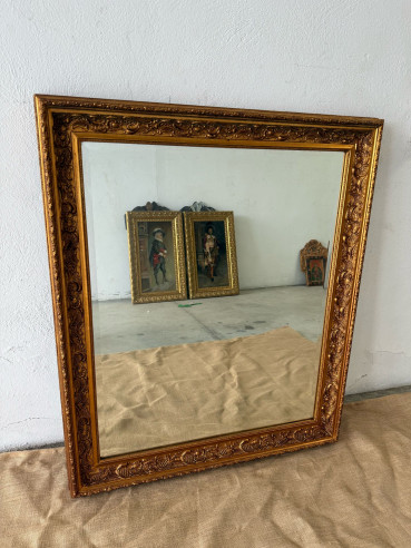 Espejo biselado con marco dorado en madera.
