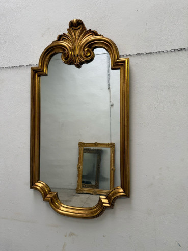 Elegante espejo con formas, dorado en oro fino.