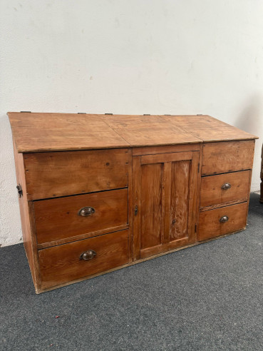 Antiguo mueble de comercio u oficio con cajones y puertas de tapa con asas a los lados.
