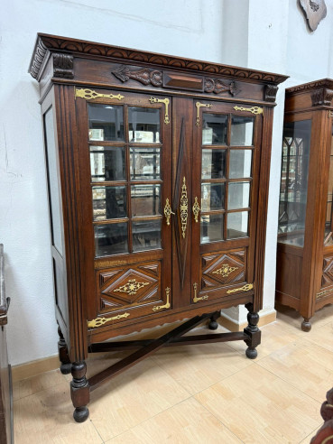 Vitrina con adornos en bronce y baldas.