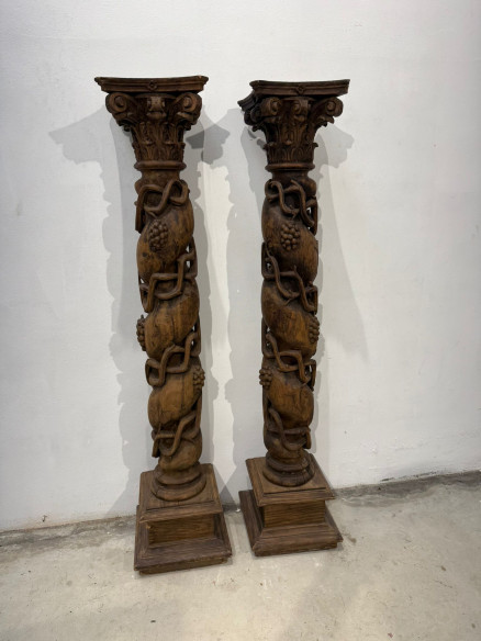 Pareja de columnas talladas en madera con racimos de uva.