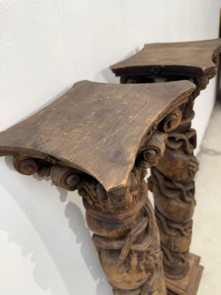 Pareja de columnas talladas en madera con racimos de uva.