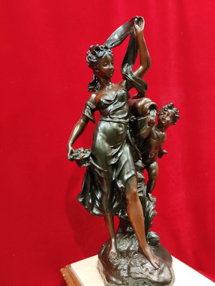 Figura de mujer y niño sobre reloj de mármol