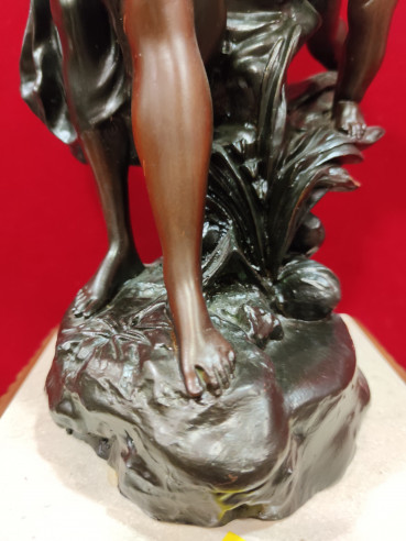 Figura de mujer y niño sobre reloj de mármol