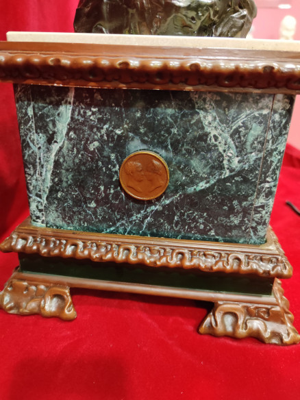 Figura de mujer y niño sobre reloj de mármol